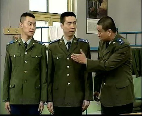 范明《炊事班的故事》中饰演老高的经典剧照，身穿军装表情严肃